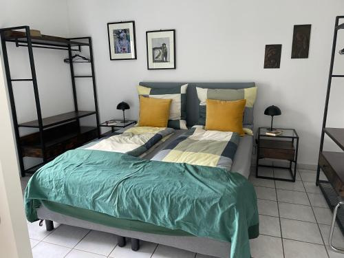 um quarto com uma cama com almofadas verdes e amarelas em Ferienwohnung -Schwalbe em Attendorn