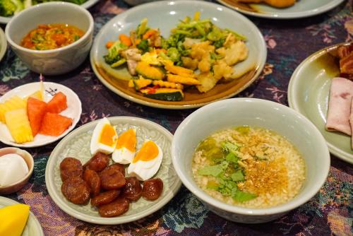 a table with plates of food and bowls of food at At Pingnakorn Nimman Hotel in Chiang Mai