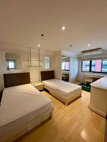 1 Schlafzimmer mit 2 Betten und einem Tisch in der Unterkunft UrbanZen Suite in Bangkok
