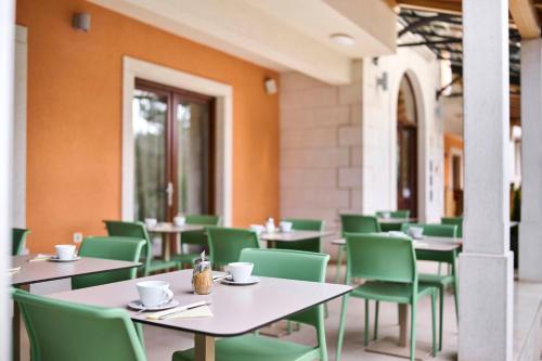 um restaurante vazio com mesas e cadeiras verdes em Villa Dobravac Wine Estate em Rovinj