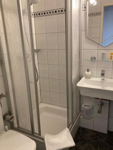 La salle de bains est pourvue d'une douche, de toilettes et d'un lavabo. dans l'établissement Ferienwohnung Schlosser, à Kiel