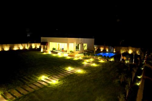 ein Gebäude mit Lichtern in der Nacht davor in der Unterkunft The Peace- A Luxury Pool Villa in Jaipur