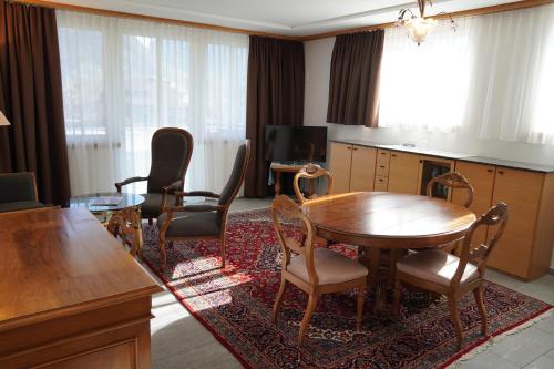 a living room with a wooden table and chairs at Carlton-Europe Vintage Adults Hotel in Interlaken