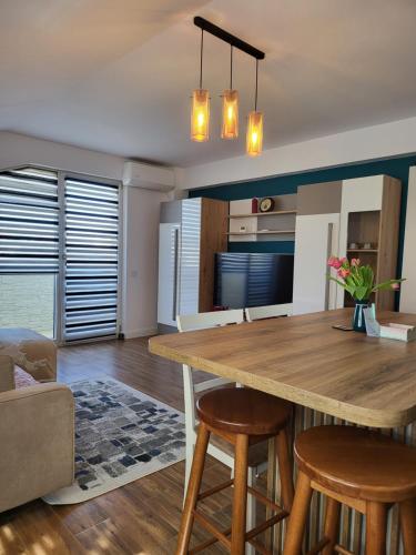 a kitchen with a wooden table and some chairs at Apartament 3camere / Penthouse in Cisnădie