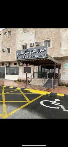 a building with a sign on the side of a street at الديوان النجدي للشقق المخدومة اقتصادي in Ukaz