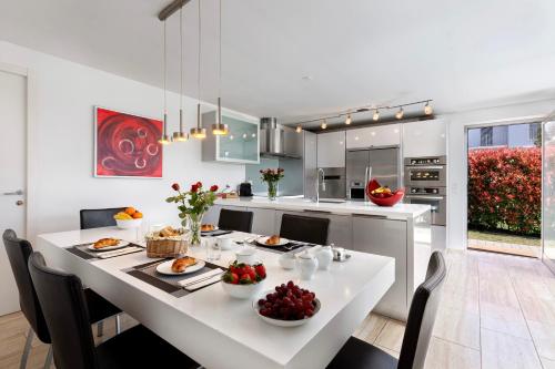 a kitchen with a white table with fruit on it at Villa Dolce Vita With Private Pool in Lugano