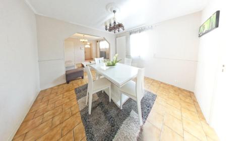 a white dining room with a white table and chairs at le blanc mesnil in Le Blanc-Mesnil