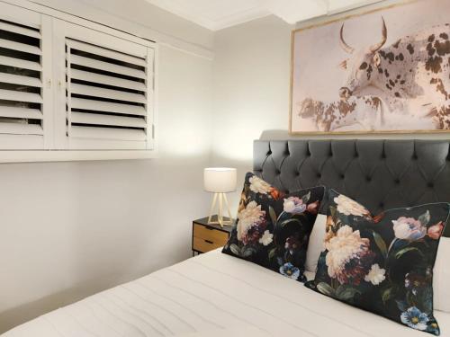 1 dormitorio con 1 cama y una foto de una vaca en 10 on Gillian Self-catering Apartments - NOT AFFECTED BY LOADSHEDDING, en Eversdal