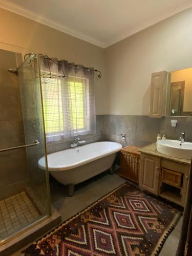a bathroom with a tub and a shower and a sink at BLessing at Lynnwood in Pretoria