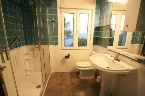 een badkamer met een toilet, een wastafel en een douche bij Casa en primera linea de mar. in Laxe
