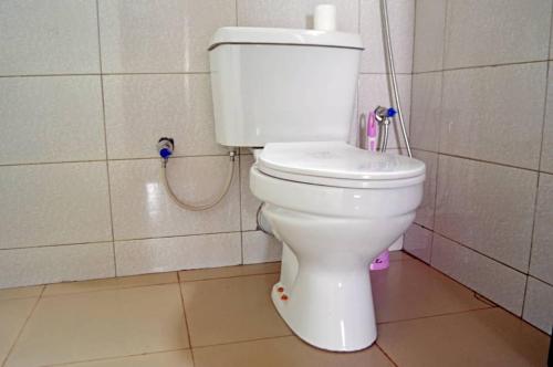 a bathroom with a white toilet in a room at Serene Homes in Jinja