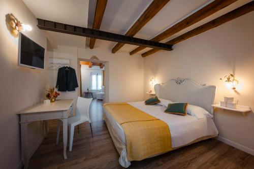 a bedroom with a bed and a desk and a television at Casale in Collina in Capriva del Friuli