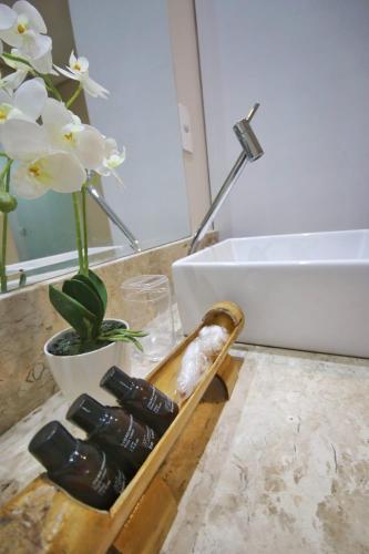 a bathroom with a sink and a tray of rocks at Parada IT in Japaratinga