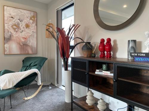 a living room with a mirror and a green chair at Luxury 4 Bedroom Family Retreat in Lincoln