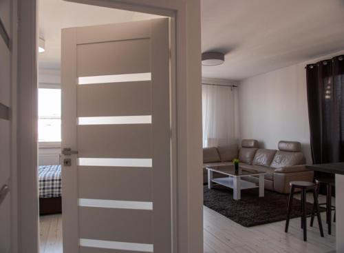 una puerta que da a una sala de estar con sofá en Apartment Kłobucka en Varsovia