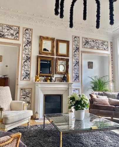 un salon avec un canapé et une cheminée dans l'établissement IXO’s The Suite, à Reims