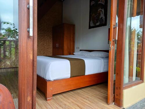 - une chambre avec un lit et une porte en verre dans l'établissement Relaxing 2 Bedroom Villa With Private Pool, à Ubud