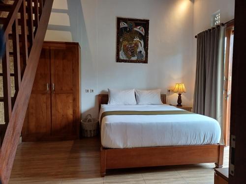 - une chambre avec un grand lit et un escalier dans l'établissement Relaxing 2 Bedroom Villa With Private Pool, à Ubud