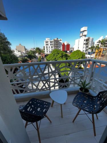 un balcón con 2 sillas y una mesa en el balcón en BE ONE III IRIGOYEN - EXCELENTE DEPARTAMENTO A ESTRENAR MODERNO, UBICADO EN EL CORAZON DEL CAMBA CUA en Corrientes