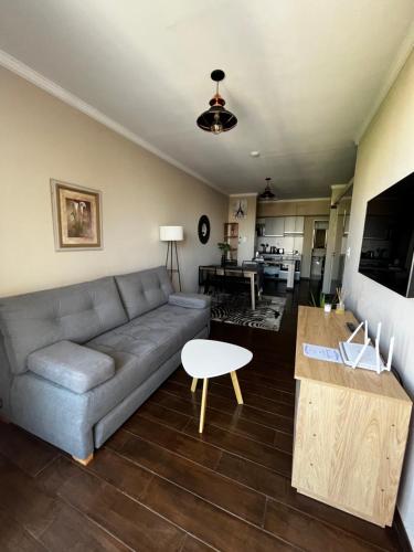 a living room with a couch and a table at BE ONE III IRIGOYEN - EXCELENTE DEPARTAMENTO A ESTRENAR MODERNO, UBICADO EN EL CORAZON DEL CAMBA CUA in Corrientes