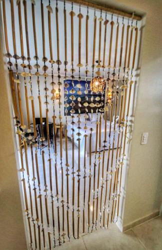 a room with a large metal wall with a chandelier at Parada IT in Japaratinga