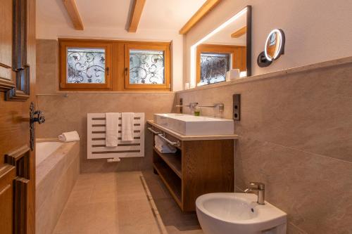 a bathroom with a sink and a tub and a toilet at Chalet Waldhaus Rappakopf in Schruns