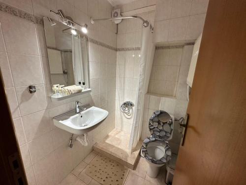 een badkamer met een toilet, een wastafel en een douche bij Elena maisonette by the sea (2) in Kamena Vourla
