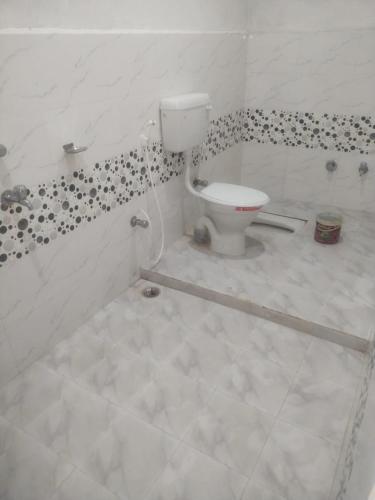Begusarai的住宿－VEDIK GRAM，一间带卫生间的浴室,铺有瓷砖地板。