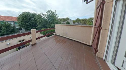 un balcone con pavimenti in legno in un edificio di le blanc mesnil a Le Blanc-Mesnil