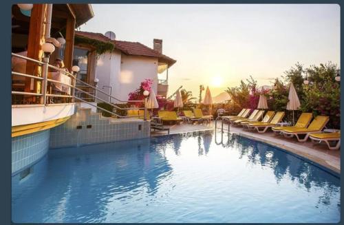 une piscine avec des chaises et des parasols dans un hôtel dans l'établissement VillaSun Kleopatra, à Alanya