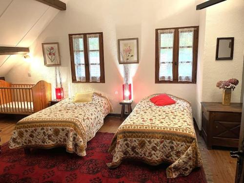 une chambre avec deux lits et deux fenêtres dans l'établissement La ferme de Quinette, à Fillinges