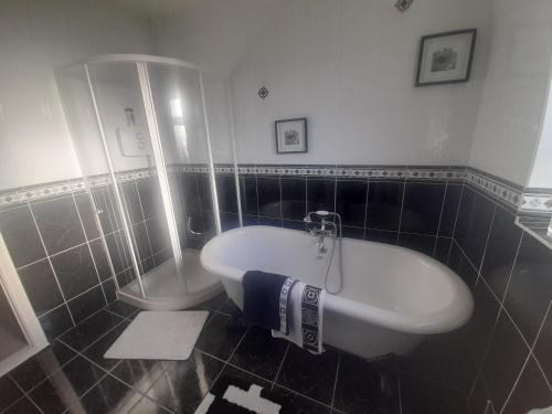 a bathroom with a tub and a toilet in it at Close to Lough Rynn Castle Mohill - Room Only in Mohill