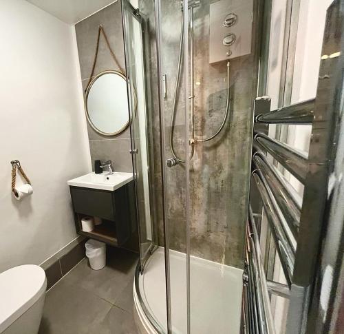 La salle de bains est pourvue d'une douche, de toilettes et d'un lavabo. dans l'établissement Farmyard Inn, à Youlgreave