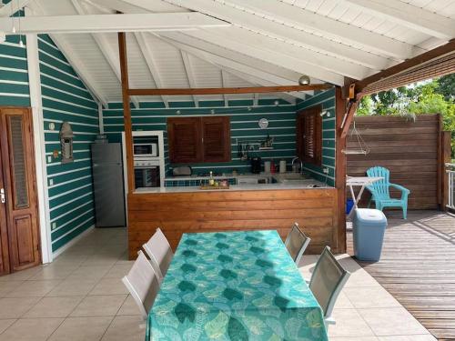 a patio with a table and a kitchen on a deck at Superbe villa face à la mer in Pointe-Noire