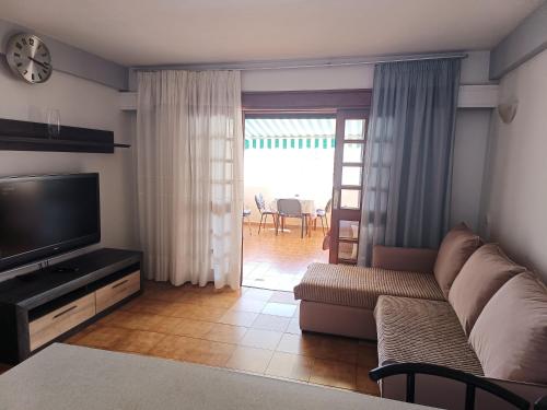 a living room with a couch and a television at Parque Royal Apartamento in Playa Fañabe