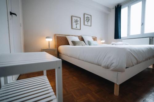 une chambre avec un grand lit blanc et une fenêtre dans l'établissement À Hauteur de Toits • Le Spacieux en Cœur de ville, à Châteauroux