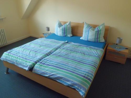 Schlafzimmer mit einem Bett mit blauer Bettwäsche und Kissen in der Unterkunft Ferienwohnung Burgenblick in Cochem