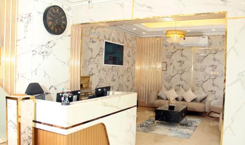 a lobby with a reception desk and a clock on the wall at Al BARAKAH HOTEL in Sharjah