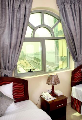 a bedroom with a window and a bed and a lamp at Al BARAKAH HOTEL in Sharjah