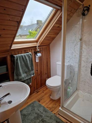 une salle de bain avec toilettes, lavabo et fenêtre dans l'établissement Petit cottage breton, à Saint-Mayeux