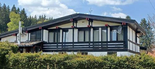 a house with a black and white at Ferienwohnung GABI in Forbach