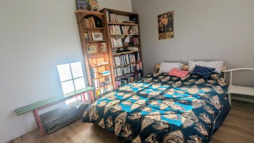 ein Schlafzimmer mit einem Bett und einem Bücherregal in der Unterkunft Maison avec jardin aux portes de Paris in Gentilly