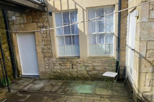 a white chair sitting outside of a building with a door at The Courtyard in Bath