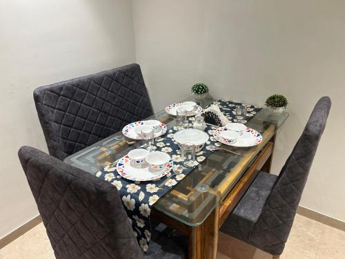a dining room table with plates and glasses on it at 1BHK In Hiranandani Powai (D) in Mumbai