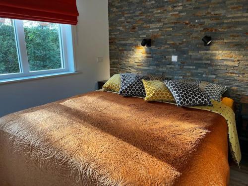 een bed in een slaapkamer met een bakstenen muur bij De Egelburcht in Garderen
