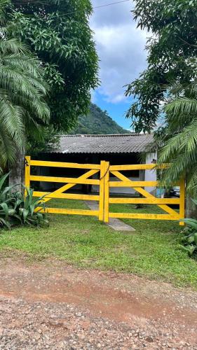 una cerca amarilla frente a una casa en Casa de temporada na Serra Macaense, en Macaé
