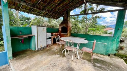 cocina con mesa y sillas en una habitación en Casa de temporada na Serra Macaense, en Macaé