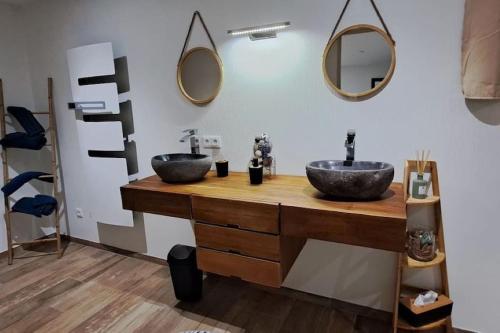 une salle de bain avec deux lavabos et des miroirs au mur dans l'établissement Grand Appartement Cosy Chez Pépette à 5 min de Colmar, à Houssen