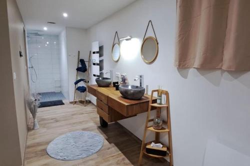 une salle de bain avec un lavabo et deux miroirs au mur dans l'établissement Grand Appartement Cosy Chez Pépette à 5 min de Colmar, à Houssen