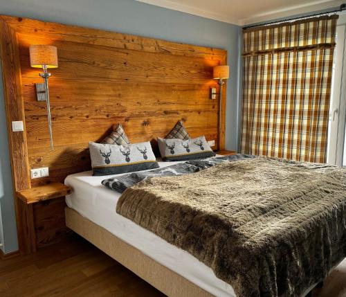 sypialnia z dużym łóżkiem z drewnianym zagłówkiem w obiekcie Ferienwohnung-Königsschlösser w Füssen